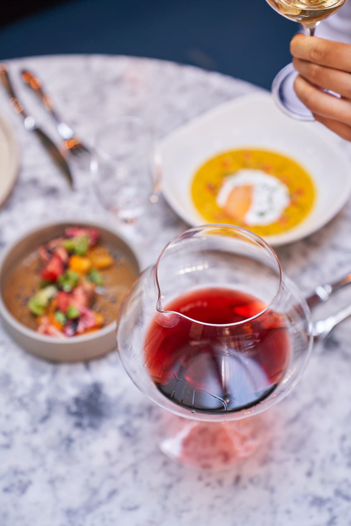 A wine decanter and a few plates of food.
