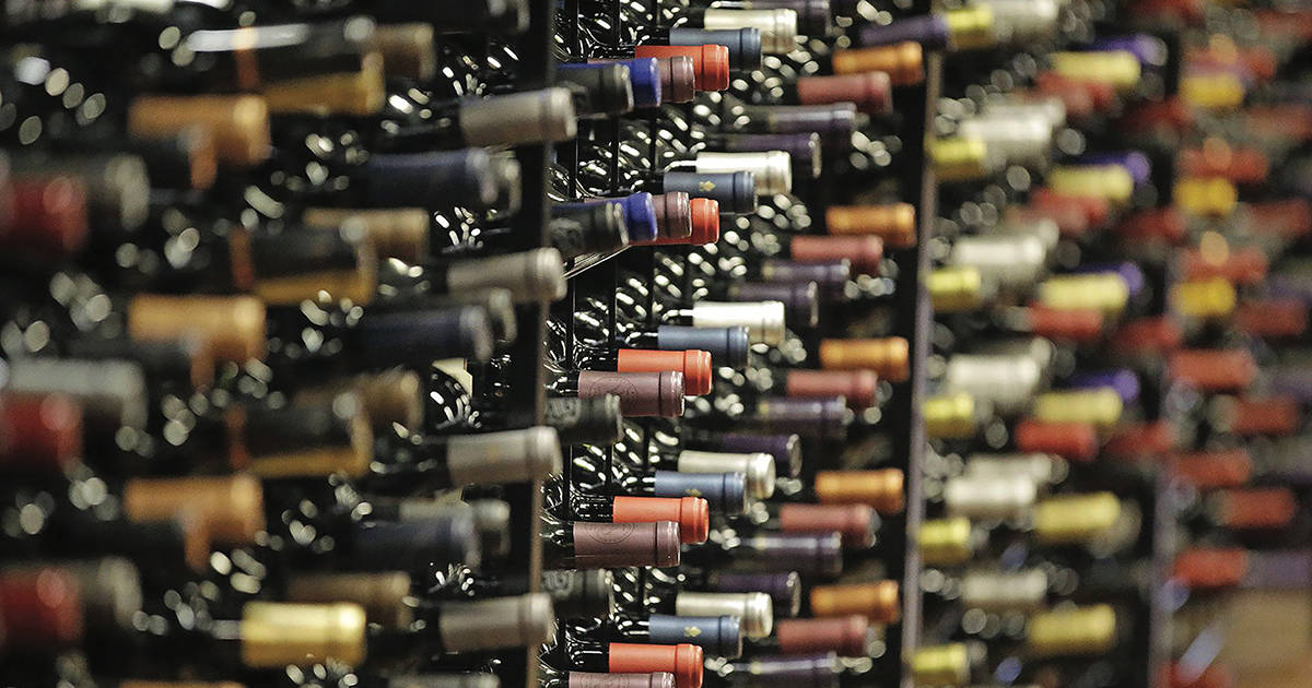Bottles of different types of wine in a wine cellar.