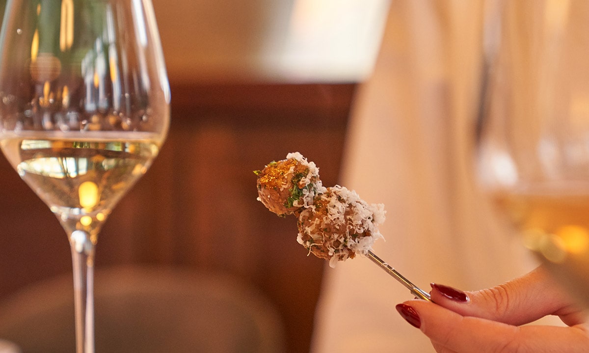 An appetizer served with a glass of white wine.