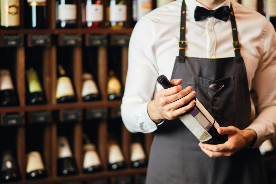 Wine sommelier holding a bottle - Royal Glass
